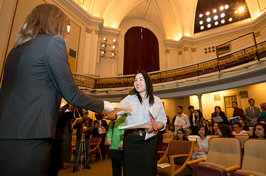 Haruethi Francis, originally from Thailand, picks up paperwork after the naturalization ceremony on April 18 at Washington Hall, photo by Becky Malewitz, South Bend Tribune