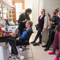 With makeup and music, cast members prepare to take the stage.