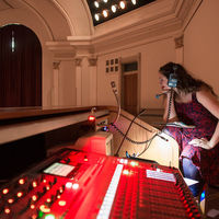 From the balcony at Washington Hall, director Christy Burgess works sound and lights as she watches the performance.