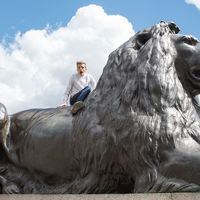 Robinson Shakespeare Company ensemble member Forest Wallace rides a lion in London's Trafalgar Square.