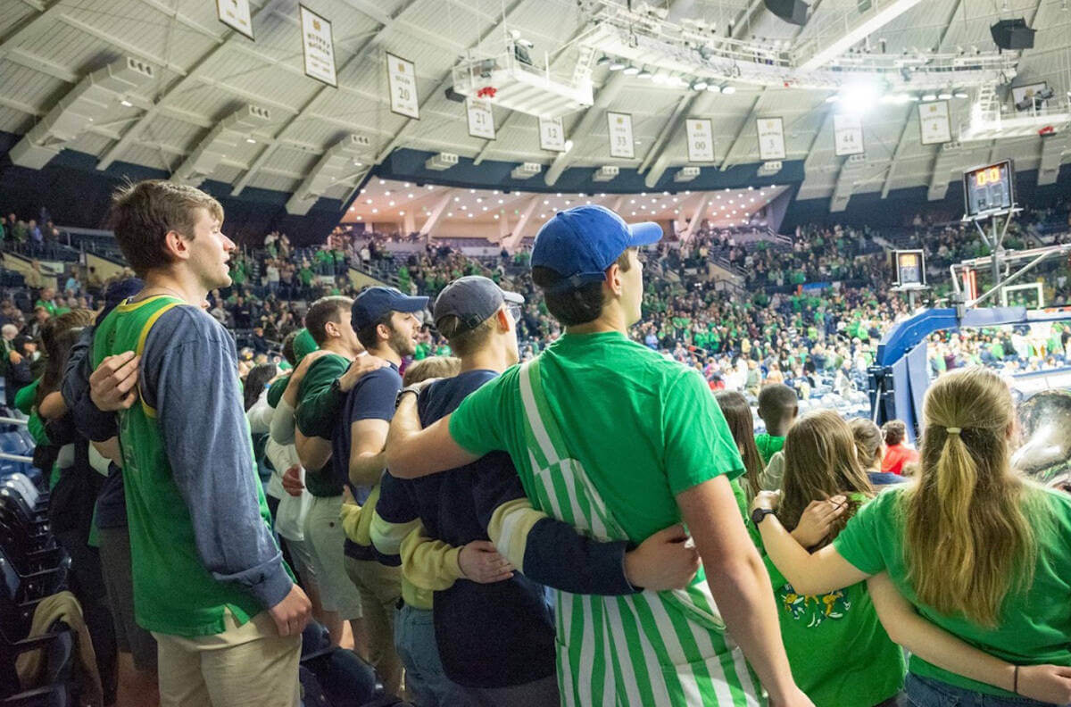Students with arms around each other sing the alma mater after Notre Dame's women's basketball win over Ole Miss in the NCAA Tournament.