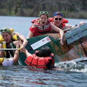 Students scream and laugh as their boat tips over and some of them fall into the lake during the Fisher Regatta.