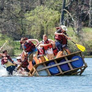 Students fall into the lake as their boat capsizes during the Fisher Regatta.