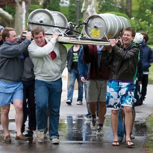 Students carry the boat they made for the Fisher Regatta, which will be kept afloat by beer kegs.