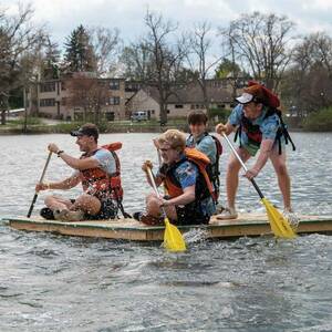 Students paddle a raft in the Fisher Regatta on St. Mary's Lake.