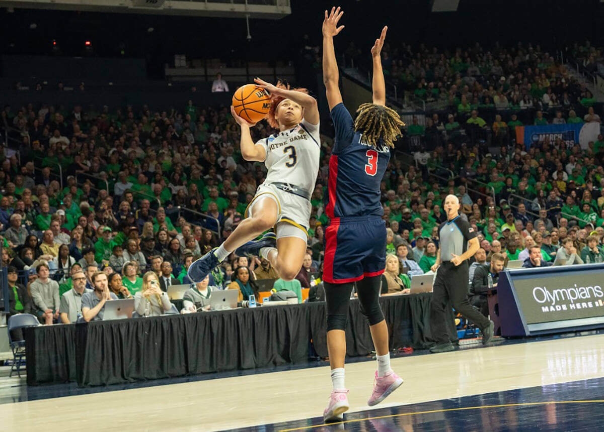 Notre Dame's Hannah Hidalgo leaps toward the basket for a shot over an Ole Miss defender with outstretched arms.