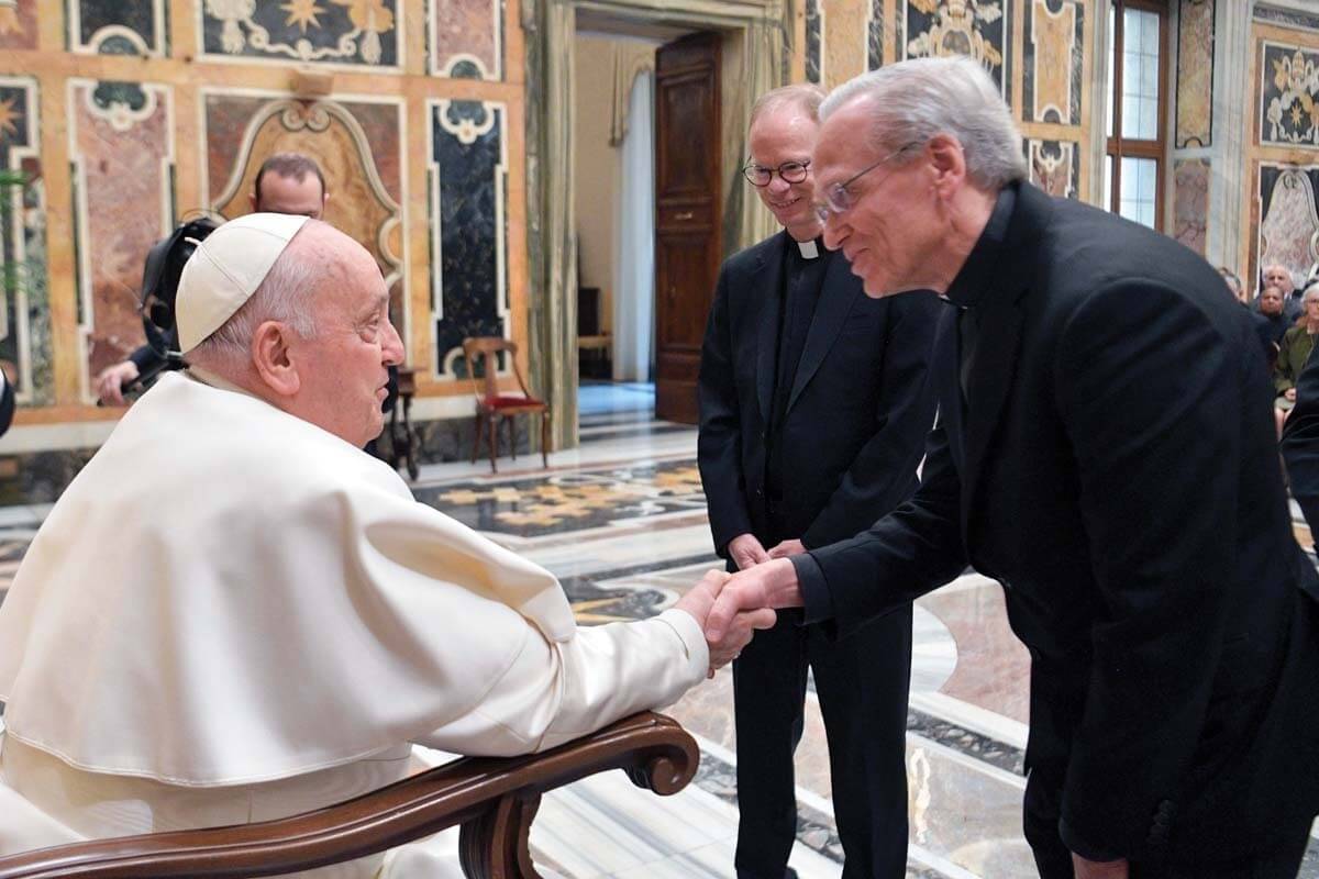 Pope Francis shakes hands with University President Rev. John I. Jenkins with incoming president Rev. Bob Dowd standing nearby.