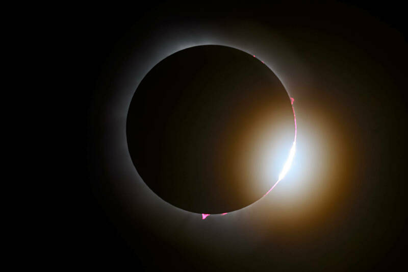 A photo of a full solar eclipse on April 8 with only a glimpse of sunlight visible on the lower right-hand side of the sphere amid the dark outline of the moon.