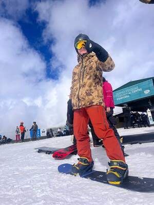 Sam Coffman wearing goggles and heavy winter clothing preparing for a snowboarding run