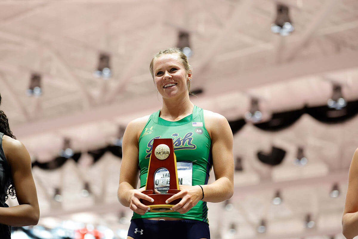 Jadin O'Brien stands on a podium holding her national championship trophy