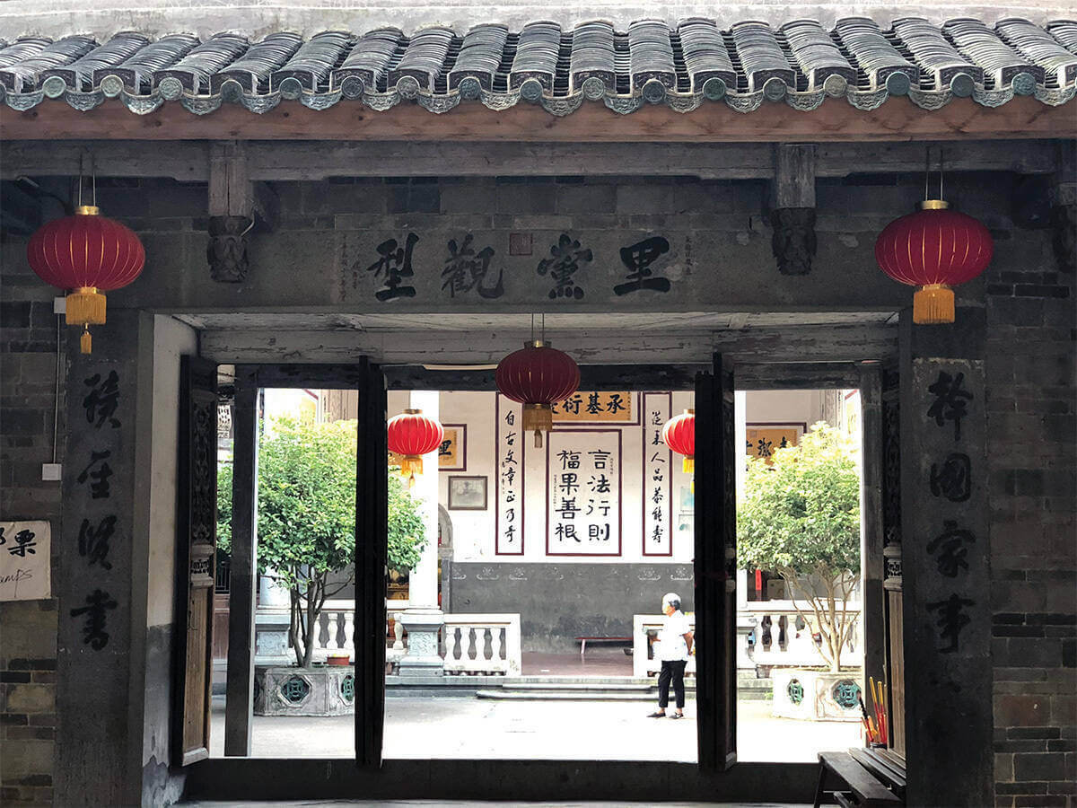 An entryway to Zhencheng Lou, with Chinese characters around the threshold and more visible in the background.