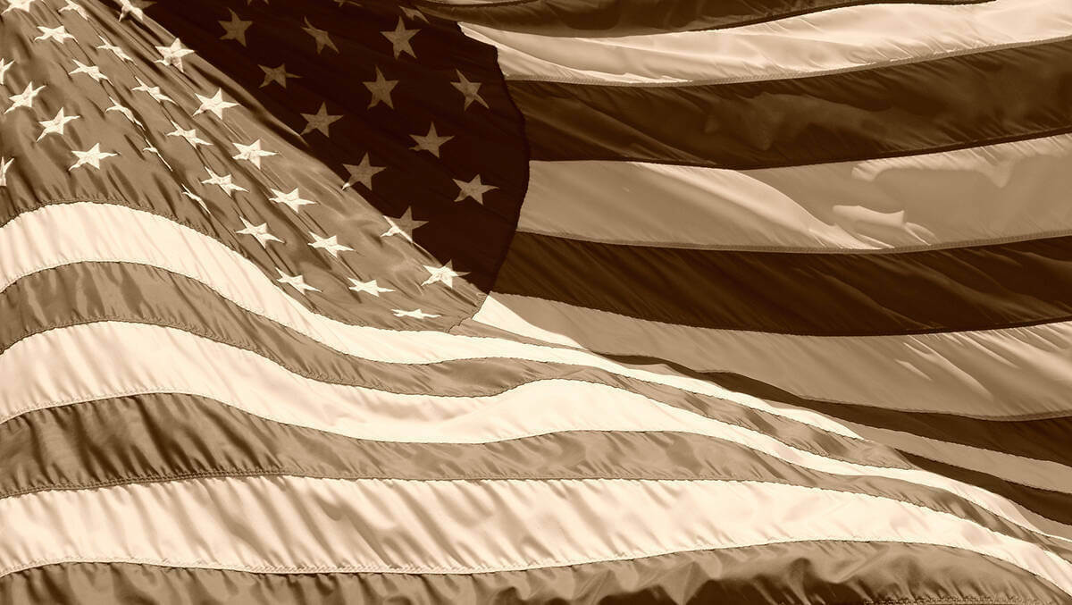 A sepia-toned image of a waving American flag