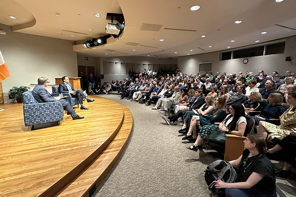 Former Irish prime minister Leo Varadkar sits on stage next to professor Colin Barr during a discussion with an overflow crowd