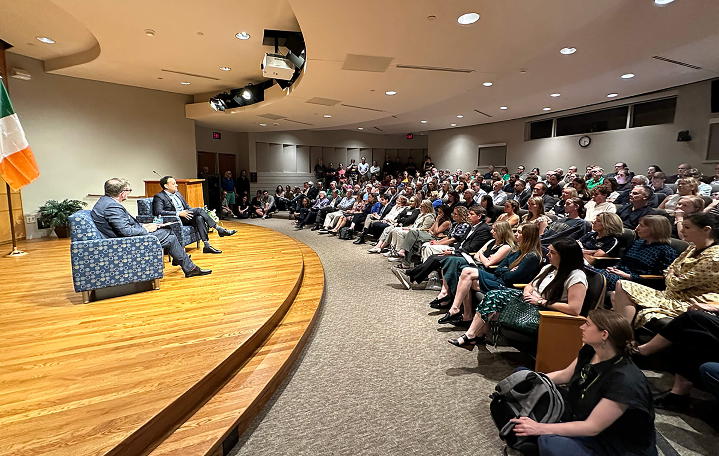 Former Irish prime minister Leo Varadkar sits on stage next to professor Colin Barr during a discussion with an overflow crowd