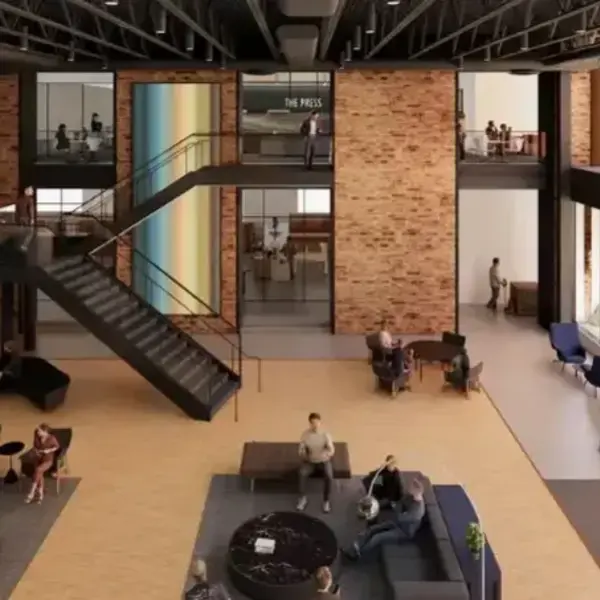 Modern, multi-level atrium with brick accents, stairs, and people socializing.